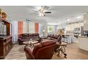 Inviting living room featuring comfortable leather seating, neutral walls, wood-look floors, and open access to kitchen at 5218 W Lydia Ln, Laveen, AZ 85339