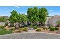 Beautifully landscaped front yard with mature trees, brick driveway and desert landscaping at 6243 E Camelback Rd, Scottsdale, AZ 85251