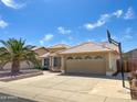 Single-Gathering home featuring a two-car garage, tiled roof, mature palm tree and basketball hoop on the driveway at 8535 W Willow Ave, Peoria, AZ 85381