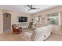 Cozy living room featuring comfortable leather seating, a ceiling fan, and natural light at 1085 W Ayrshire Trl, San Tan Valley, AZ 85143
