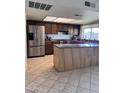 Traditional kitchen with wood cabinets, stainless steel fridge, kitchen island, and granite countertops at 11038 N 53Rd Dr, Glendale, AZ 85304