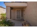 Covered front porch with desert landscaping and a security door at 12517 W Santa Fe Ln, El Mirage, AZ 85335