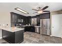 Kitchen with stainless steel appliances and black cabinets at 12517 W Santa Fe Ln, El Mirage, AZ 85335