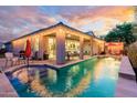 Resort-style backyard features a refreshing pool, covered patio, and cozy seating areas, ideal for outdoor living at 15796 W Shaw Butte Dr, Surprise, AZ 85379