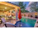 Charming backyard with a sparkling pool, covered patio, and well-maintained landscaping perfect for relaxing and entertaining at 15796 W Shaw Butte Dr, Surprise, AZ 85379
