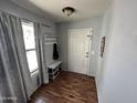 Inviting entryway with wood floors, coat rack, bench, and natural light from the window at 16010 N 170Th Ln, Surprise, AZ 85388