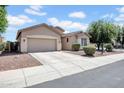 Charming single-story home featuring a two-car garage and a low-maintenance landscaped yard at 16861 W Ironwood St, Surprise, AZ 85388