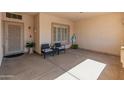Cozy covered front porch with seating, a secure front door, and views of the manicured front yard at 21335 N 64Th Ave, Glendale, AZ 85308