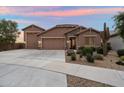 Beautiful single-story home featuring a three-car garage, desert landscaping, and a charming stone facade at 24280 N 164Th Dr, Surprise, AZ 85387