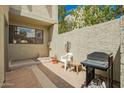 Private patio area featuring a grill, chair, table, and desert landscape elements at 2524 S El Paradiso -- # 122, Mesa, AZ 85202