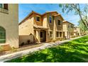 Tan stucco two-story townhome featuring desert landscaping and covered entryway at 3485 S Seneca Way, Gilbert, AZ 85297