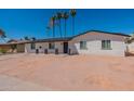 Inviting single-level home boasting a pristine white facade, complemented by drought-tolerant landscaping and a clear blue sky at 3802 W Mission Ln, Phoenix, AZ 85051