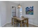 Dining room features a wooden table set beneath an industrial light fixture and bright natural light at 3843 E Hazeltine Way, Chandler, AZ 85249