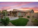 A spacious backyard featuring a covered patio and artificial grass at 4020 N 151St Dr, Goodyear, AZ 85395