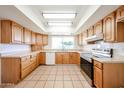 Well-lit kitchen features ample cabinetry, tile floor, stainless steel oven, and bright countertops at 4153 W Sunnyside Ave, Phoenix, AZ 85029