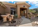 Inviting home featuring custom concrete water features, a gravel yard, and an arched entry at 41910 N Long Cove Way, Anthem, AZ 85086