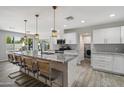Open kitchen with granite countertops, white cabinets, pendant lighting, and a view of the backyard at 4904 E Tierra Buena Ln, Scottsdale, AZ 85254