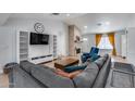 Cozy living room with a large sofa, brick fireplace, built-in shelving, and a large wall mounted television at 5228 W Aster Dr, Glendale, AZ 85304