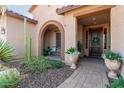 Inviting front porch with stone pavers and decorative flower pots, leading to a wood front door at 6125 E Hodges St, Cave Creek, AZ 85331