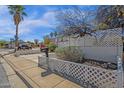 Charming home features mature landscaping, desert plants, and a well-maintained yard with a white lattice fence at 6441 E Colby St, Mesa, AZ 85205