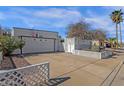 Charming single-story home features mature landscaping, desert plants, and a well-maintained driveway, with a lattice fence at 6441 E Colby St, Mesa, AZ 85205