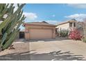 Single-story house featuring desert landscaping, a two-car garage, and a concrete driveway at 6777 W Tether Trl, Peoria, AZ 85383