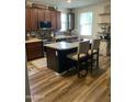 Well-lit kitchen featuring an island with barstool seating, dark cabinetry, and a modern backsplash at 7412 E Flower Ave, Mesa, AZ 85208