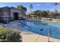 Community pool featuring a splash pad, clubhouse, a desert tree in the water, and plenty of seating at 7412 E Flower Ave, Mesa, AZ 85208