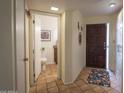 Home entryway with tile flooring leading to half bath and featuring stylish front door and closet space at 7755 E Thomas Rd # 17, Scottsdale, AZ 85251