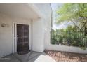 Inviting front entrance featuring a decorative door, complemented by lush greenery and stone landscaping at 7755 E Thomas Rd # 17, Scottsdale, AZ 85251
