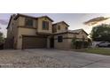 A two-story home features a 2-car garage, desert landscaping, and a concrete driveway at 8221 W Hess Ave, Phoenix, AZ 85043