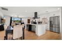 Stylish, open-concept kitchen featuring white cabinets, stainless appliances, and an adjacent dining area at 8631 E Jackrabbit Rd, Scottsdale, AZ 85250