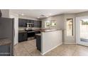 Modern kitchen features stainless steel appliances and dark cabinets at 906 S 242Nd Dr, Buckeye, AZ 85326