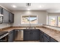 This kitchen features stainless steel appliances, dark cabinets, and tile flooring at 906 S 242Nd Dr, Buckeye, AZ 85326