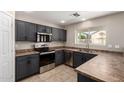 Features in this kitchen include stainless steel appliances, dark cabinets, and neutral countertops at 906 S 242Nd Dr, Buckeye, AZ 85326