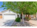 Charming single-story home featuring a well-manicured lawn with mature trees and a two-car garage at 10038 E Keats Ave, Mesa, AZ 85209