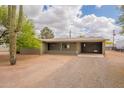 Exterior view of the home, featuring a covered carport, a well-kept lawn and desert landscaping at 10437 E Boulder Dr, Apache Junction, AZ 85120
