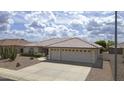 Charming single-story home featuring a well-manicured front yard, a tile roof, and a three-car garage at 11003 E Kiva Ave, Mesa, AZ 85209