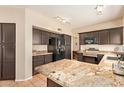 Kitchen features dark cabinetry and a large island with granite countertops at 1431 W Mountain Sky Ave, Phoenix, AZ 85045