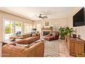 Cozy living room with a fireplace, ceiling fan, and leather furniture at 1431 W Mountain Sky Ave, Phoenix, AZ 85045
