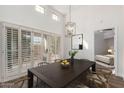 The bright dining room features plantation shutters and a modern chandelier at 14458 W Zuni Trl, Surprise, AZ 85374