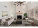 Bright living room with fireplace, high ceilings, neutral walls, and shuttered windows at 14458 W Zuni Trl, Surprise, AZ 85374