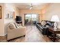 Comfortable living room with wood flooring, plush seating, and a sliding glass door to a balcony at 14950 W Mountain View Blvd # 7309, Surprise, AZ 85374