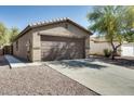 Spacious two-car garage with a concrete driveway and low-maintenance landscaping at 16188 W Boca Raton Rd, Surprise, AZ 85379