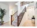 Bright foyer features a staircase with decorative iron balusters and neutral tile flooring at 1633 W Lacewood Pl, Phoenix, AZ 85045