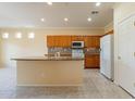 Bright kitchen features granite countertops, tiled backsplash, and modern appliances at 20627 N Lemon Drop Dr, Maricopa, AZ 85138