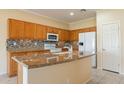 Bright kitchen features granite countertops, tiled backsplash, and modern appliances at 20627 N Lemon Drop Dr, Maricopa, AZ 85138