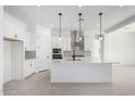 Bright kitchen with island, pendant lighting, stainless appliances, and white cabinetry at 24152 N 172Nd Ave, Surprise, AZ 85387