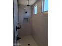 Modern shower with vertical white tiles, matte black hardware, a recessed shelf, and a window providing natural light at 24152 N 172Nd Ave, Surprise, AZ 85387