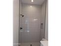 Modern bathroom shower featuring sleek white tiled walls and black fixtures at 24152 N 172Nd Ave, Surprise, AZ 85387